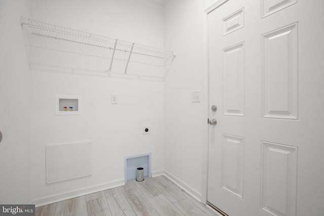 washroom with hookup for an electric dryer, hookup for a washing machine, light wood-type flooring, and baseboards