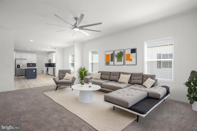 living area featuring light colored carpet, ceiling fan, recessed lighting, and baseboards