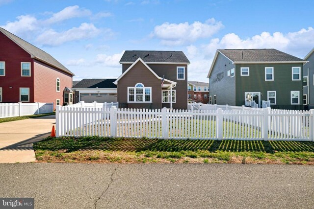 traditional-style home with a fenced front yard and concrete driveway