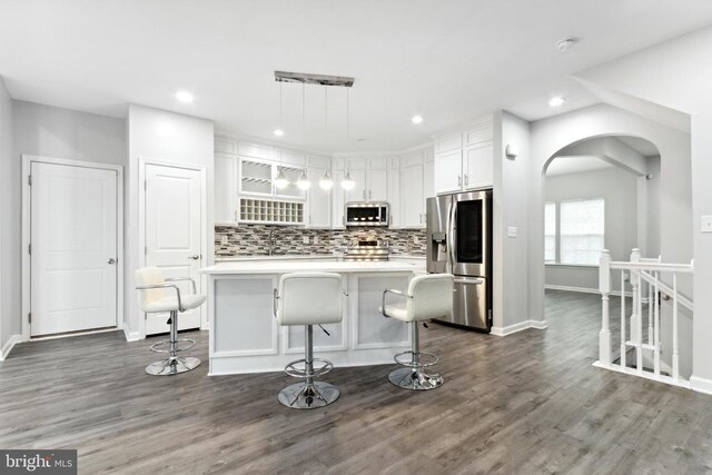 kitchen featuring appliances with stainless steel finishes, white cabinets, baseboards, tasteful backsplash, and recessed lighting