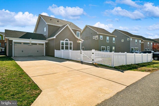 view of front of house with a garage, a residential view, concrete driveway, and fence