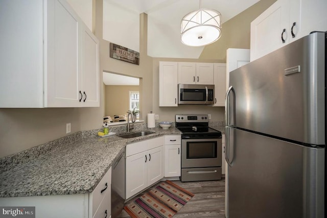 10118 New Scotland Dr, Fredericksburg, VA 22408 - kitchen with stainless steel appliances, a sink, white cabinets, dark wood finished floors, and light stone countertops