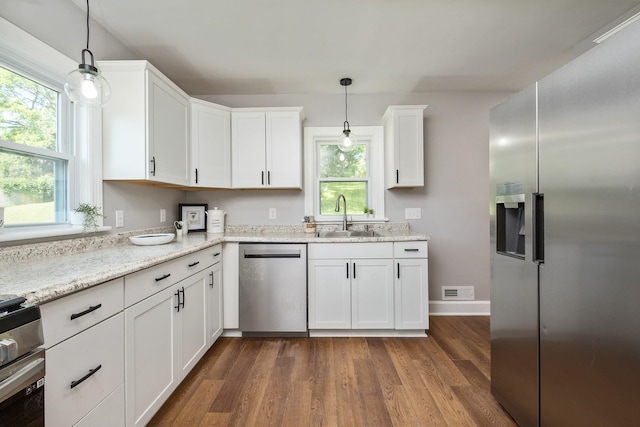 928 Baylor St, Staunton, VA 22401 - kitchen featuring stainless steel appliances, a sink, white cabinets, dark wood-style flooring, and hanging light fixtures