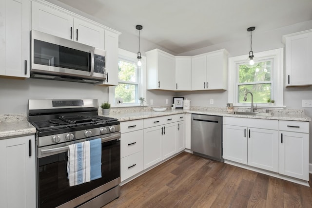 928 Baylor St, Staunton, VA 22401 - kitchen featuring appliances with stainless steel finishes, a sink, white cabinets, dark wood-type flooring, and hanging light fixtures