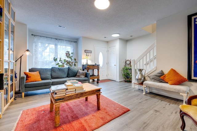 1045 Alexander Hamilton Ln, Harrisonburg, VA 22802 - living room featuring a textured ceiling, light wood-type flooring, stairway, and baseboards