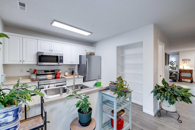 1045 Alexander Hamilton Ln, Harrisonburg, VA 22802 - kitchen with appliances with stainless steel finishes, white cabinets, light countertops, and light wood finished floors