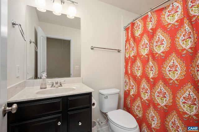 bathroom featuring toilet, vanity, and a shower with curtain