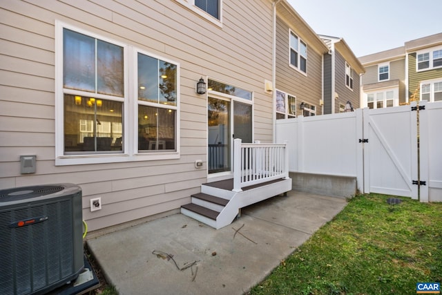 exterior space with a gate, fence, and central AC