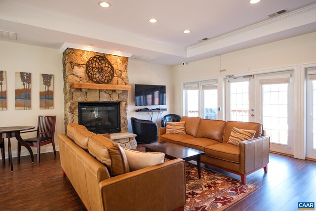 living area with a healthy amount of sunlight, dark wood-style flooring, ornamental molding, and visible vents