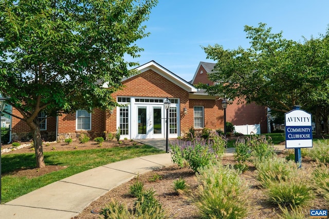 bungalow-style home with brick siding and french doors