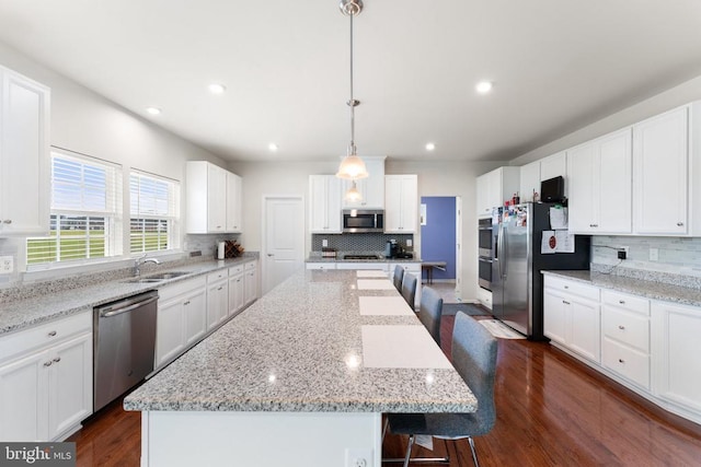 12804 Monterey Ct, Fredericksburg, VA 22407 - kitchen featuring stainless steel appliances, decorative backsplash, a sink, a center island, and dark wood-style floors
