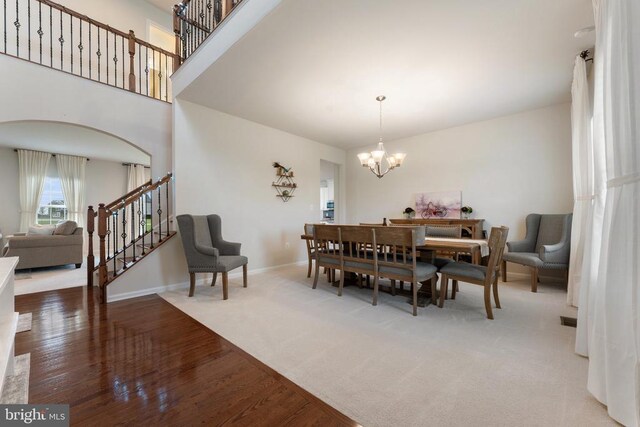 12804 Monterey Ct, Fredericksburg, VA 22407 - dining room with a chandelier, wood finished floors, arched walkways, baseboards, and stairway