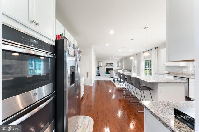 12804 Monterey Ct, Fredericksburg, VA 22407 - kitchen featuring stainless steel appliances, open floor plan, white cabinetry, dark wood-type flooring, and light stone countertops
