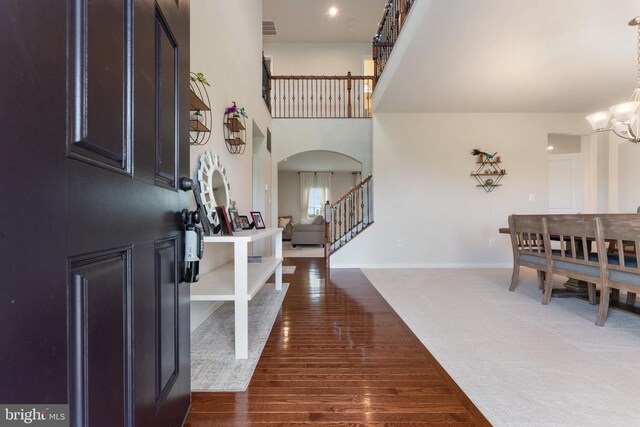 12804 Monterey Ct, Fredericksburg, VA 22407 - entryway featuring a chandelier, stairs, arched walkways, dark wood-style floors, and baseboards