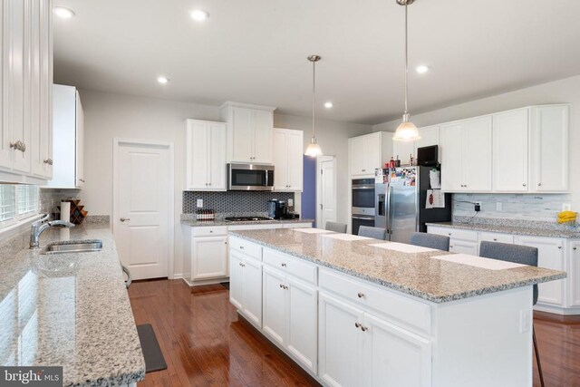 12804 Monterey Ct, Fredericksburg, VA 22407 - kitchen featuring stainless steel appliances, a sink, tasteful backsplash, a kitchen island, and white cabinets