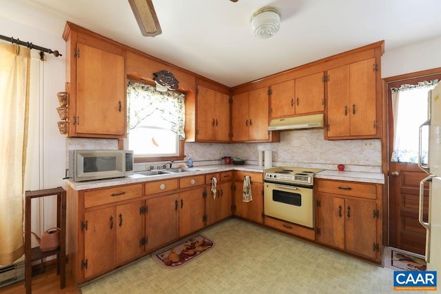 6928 Blackwells Hollow Rd, Crozet, VA 22932 - kitchen featuring stainless steel microwave, under cabinet range hood, white range with electric cooktop, a sink, and light countertops