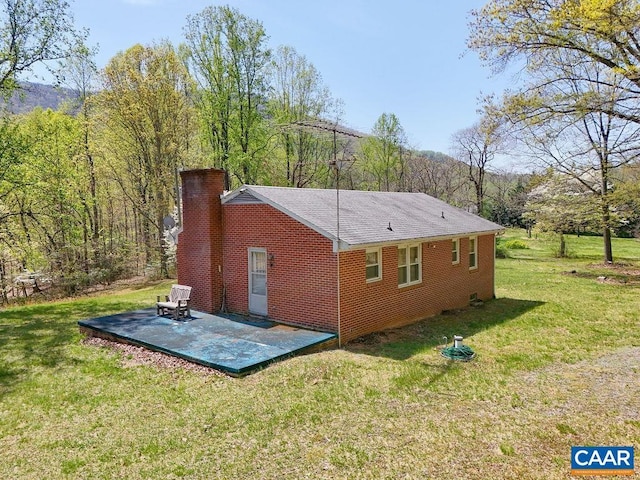 6928 Blackwells Hollow Rd, Crozet, VA 22932 - view of property exterior featuring a chimney, a patio, a lawn, brick siding, and a shingled roof