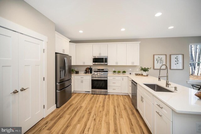 92 Mill Run, Bumpass, VA 23024 - kitchen featuring a peninsula, light wood finished floors, a sink, stainless steel appliances, and white cabinetry