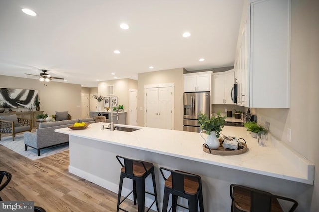 92 Mill Run, Bumpass, VA 23024 - kitchen featuring a peninsula, a breakfast bar, a sink, stainless steel appliances, and white cabinets