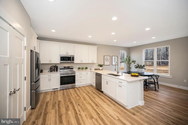 92 Mill Run, Bumpass, VA 23024 - kitchen featuring light wood-style flooring, a sink, a peninsula, stainless steel appliances, and white cabinets