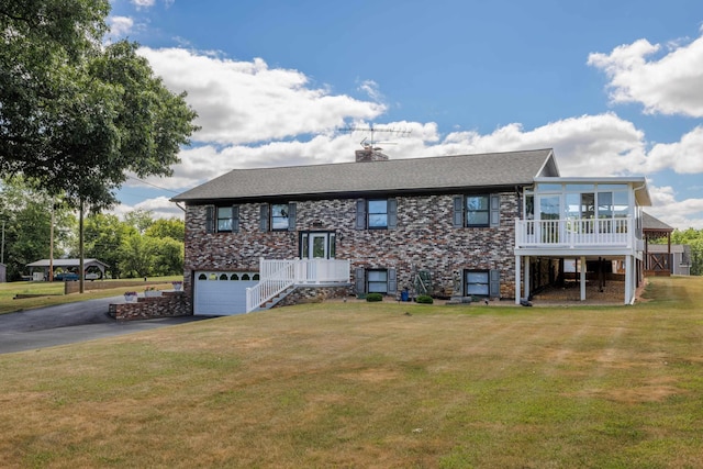 view of front of house featuring aphalt driveway, stairs, a garage, a front lawn, and a chimney