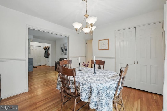  - dining area with light wood-style floors and a chandelier