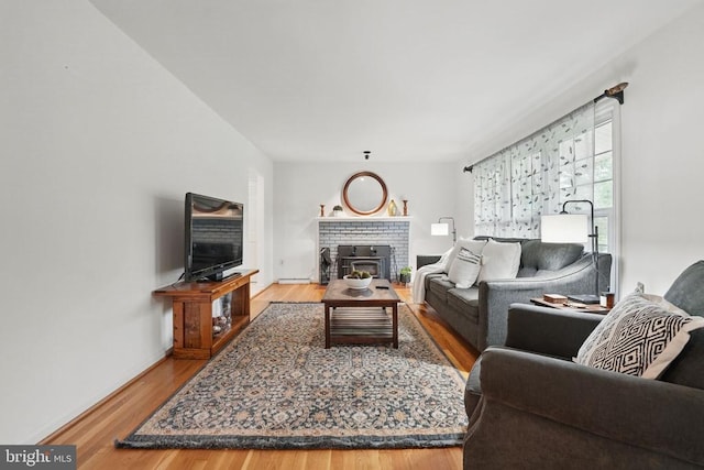  - living area with wood finished floors and a fireplace