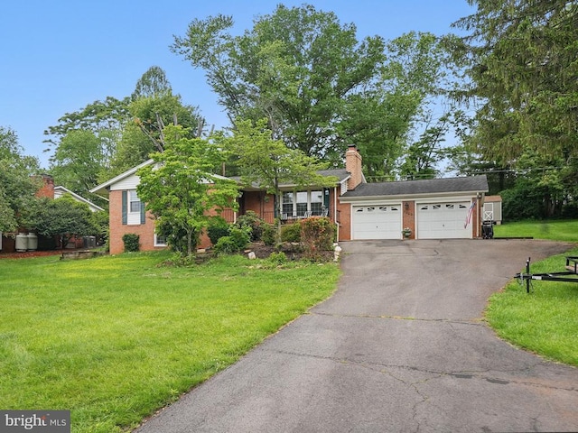 - view of front of property with asphalt driveway, an attached garage, a front yard, a chimney, and brick siding