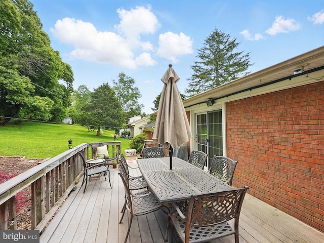  - deck with outdoor dining area and a lawn