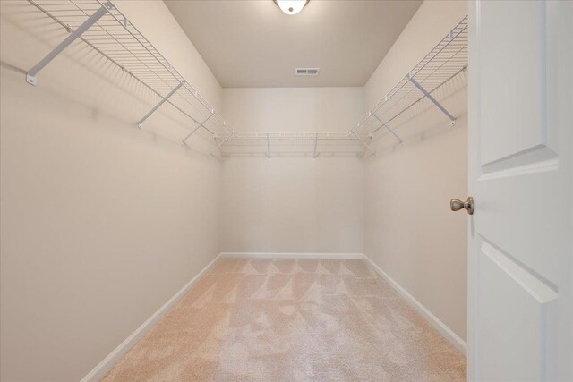 walk in closet featuring light carpet and visible vents