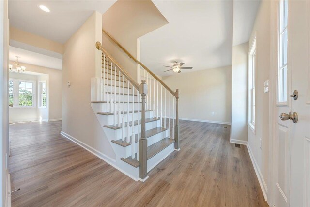foyer featuring wood finished floors, stairs, and baseboards