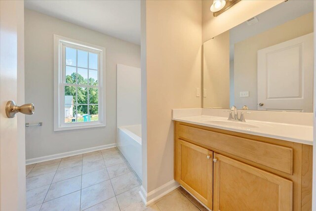 full bathroom with vanity, baseboards, tile patterned floors, and a tub to relax in