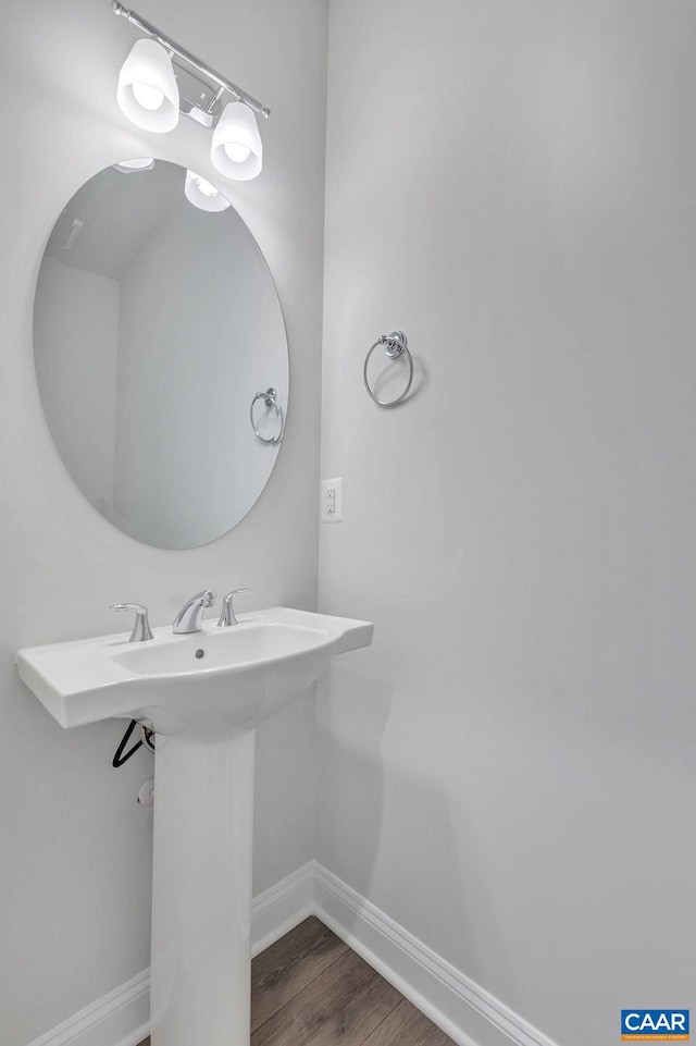 bathroom with baseboards and wood finished floors