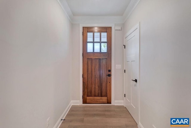 entryway featuring light wood finished floors, crown molding, and baseboards