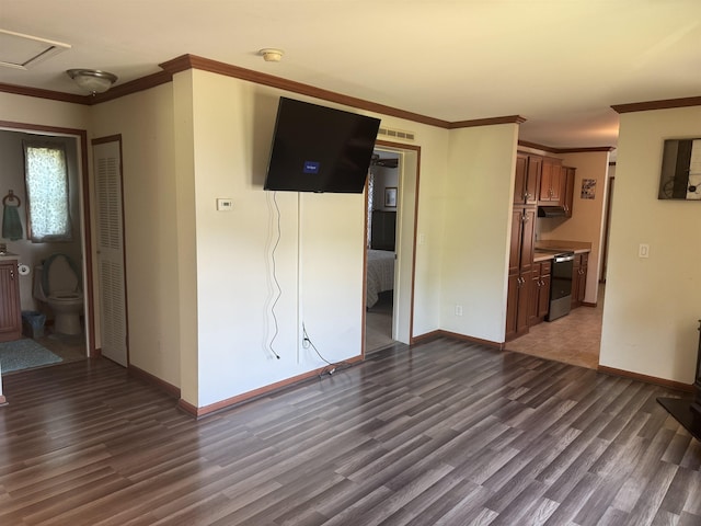 unfurnished living room featuring wood finished floors, ornamental molding, and baseboards