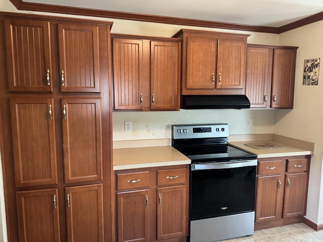 kitchen with stainless steel electric range oven, under cabinet range hood, light countertops, brown cabinetry, and ornamental molding