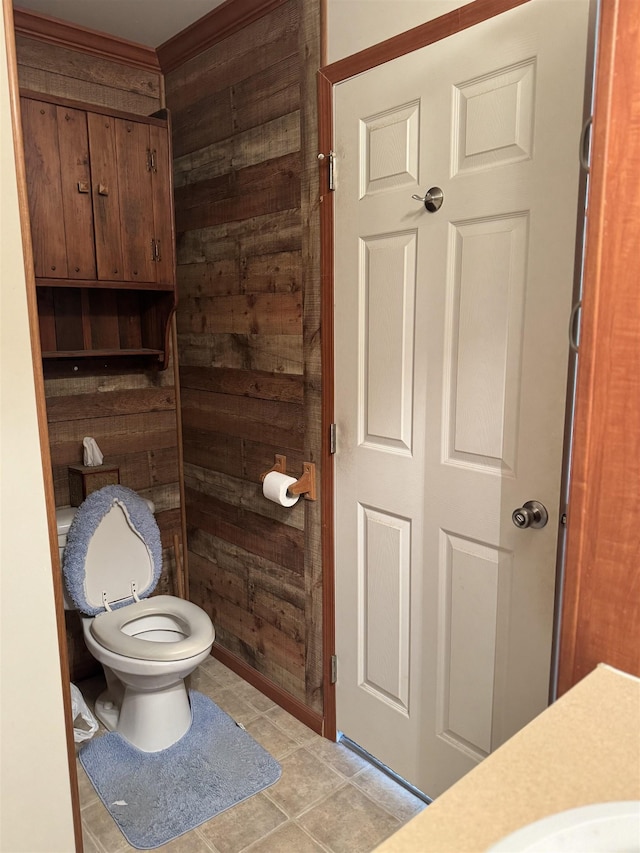 bathroom featuring wood walls, toilet, and tile patterned floors