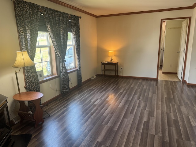 unfurnished room with wood finished floors, ornamental molding, and baseboards