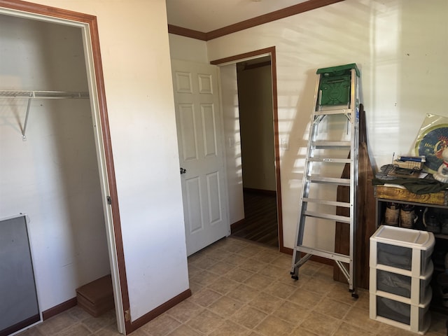 bedroom with crown molding, a closet, and baseboards