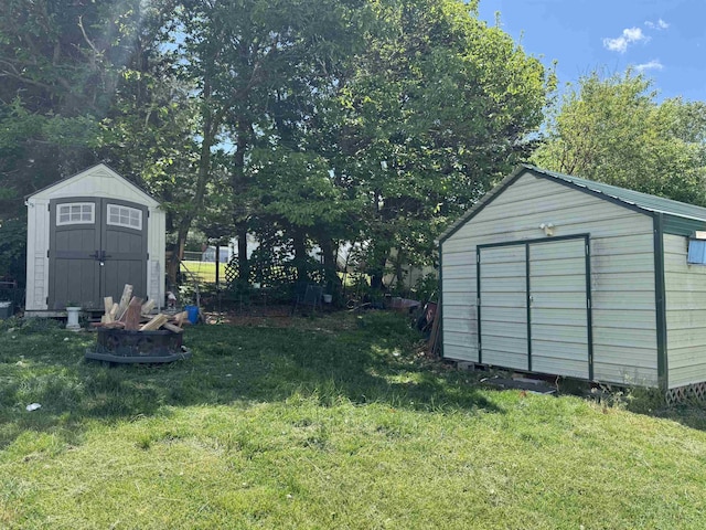view of grassy yard featuring a storage shed and an outbuilding