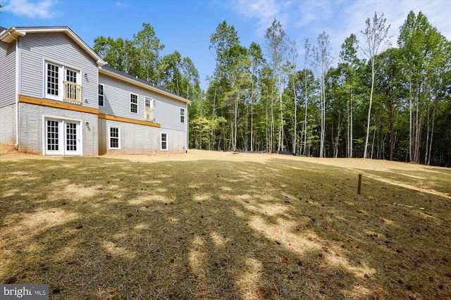 view of green lawn featuring french doors
