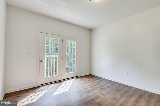 unfurnished room featuring wood finished floors and baseboards