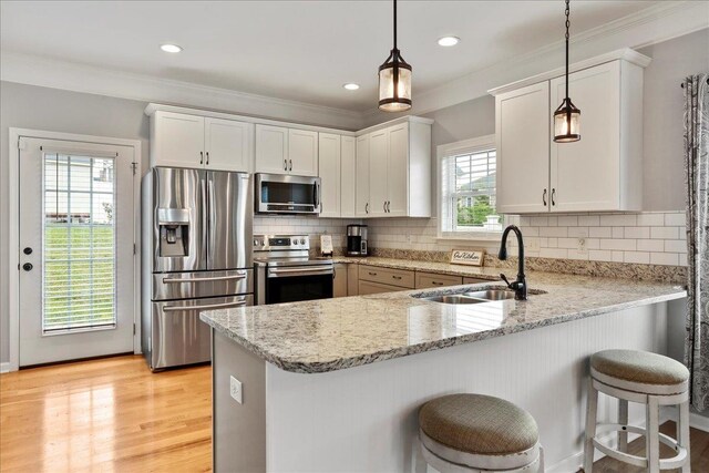 115 Beauregard Dr, Staunton, VA 24401 - kitchen with appliances with stainless steel finishes, a sink, a peninsula, hanging light fixtures, and light stone counters