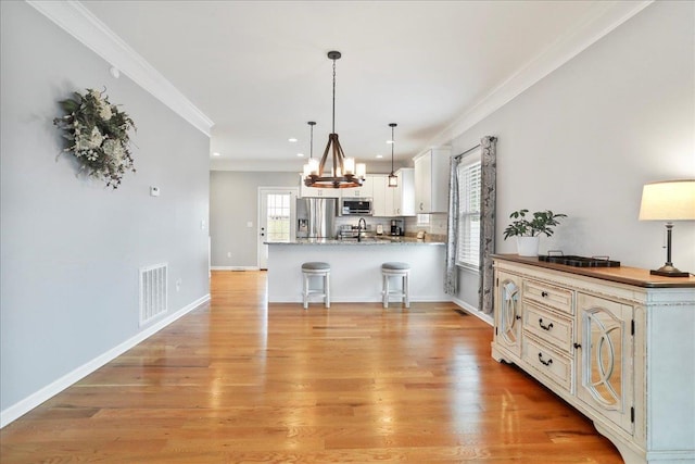 115 Beauregard Dr, Staunton, VA 24401 - kitchen with stainless steel appliances, a peninsula, a kitchen breakfast bar, ornamental molding, and recessed lighting