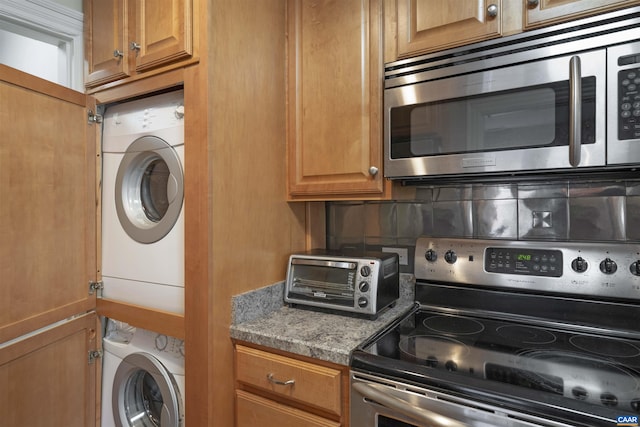 washroom with stacked washing maching and dryer, laundry area, and a toaster