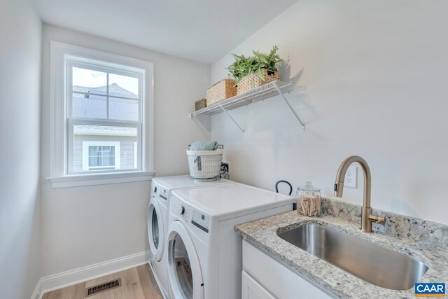 240 Thicket Run Dr, Charlottesville, VA 22911 - clothes washing area featuring washing machine and dryer, a sink, laundry area, light wood-type flooring, and visible vents