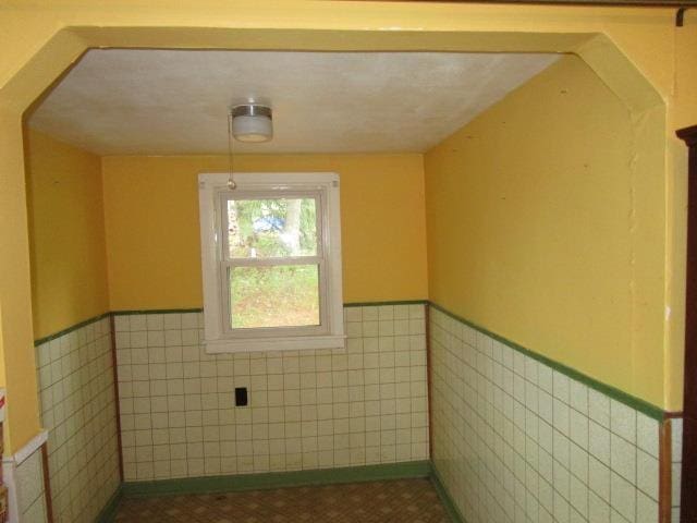 106 Grubert Ave, Staunton, VA 24401 - unfurnished room featuring a wainscoted wall, tile walls, and arched walkways