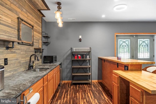7922 Madison Plantation Way, Fredericksburg, VA 22407 - kitchen with wood counters, wood walls, stainless steel microwave, brown cabinets, and dark wood-type flooring