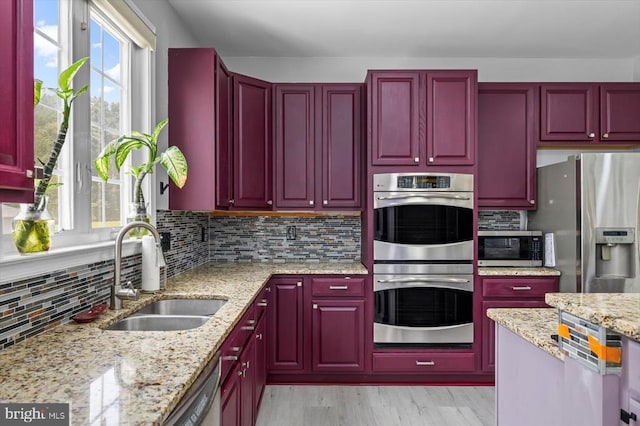 7922 Madison Plantation Way, Fredericksburg, VA 22407 - kitchen with appliances with stainless steel finishes, reddish brown cabinets, decorative backsplash, light wood-style floors, and light stone countertops