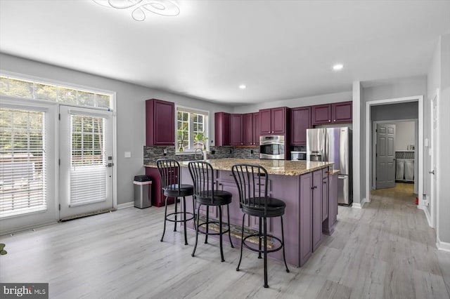7922 Madison Plantation Way, Fredericksburg, VA 22407 - kitchen featuring appliances with stainless steel finishes, reddish brown cabinets, light wood-style floors, a center island, and recessed lighting